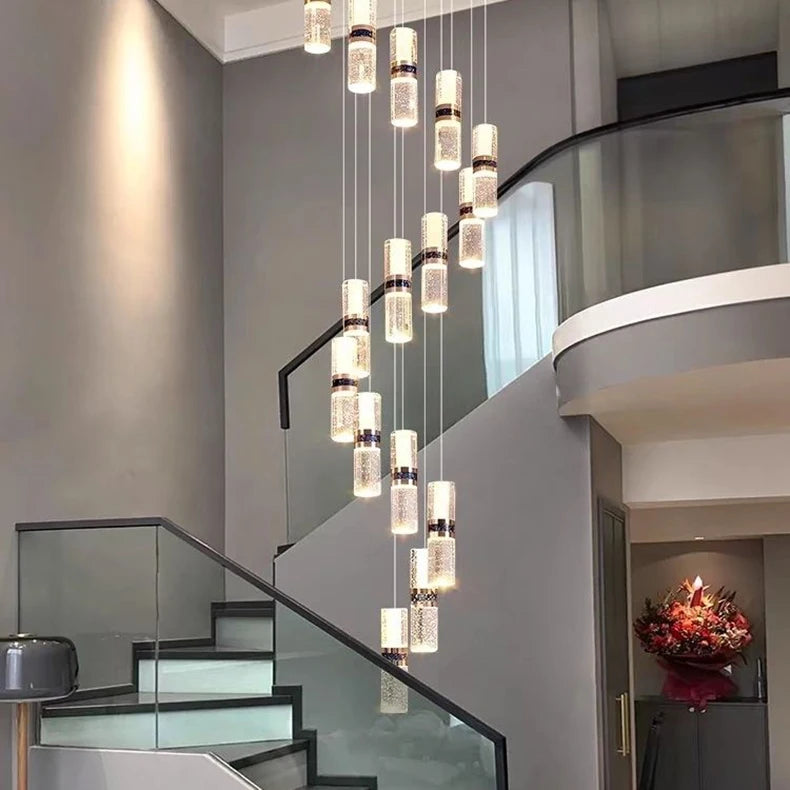 Modern crystal pendant lights illuminate a sleek staircase with glass railings, enhancing contemporary home decor.