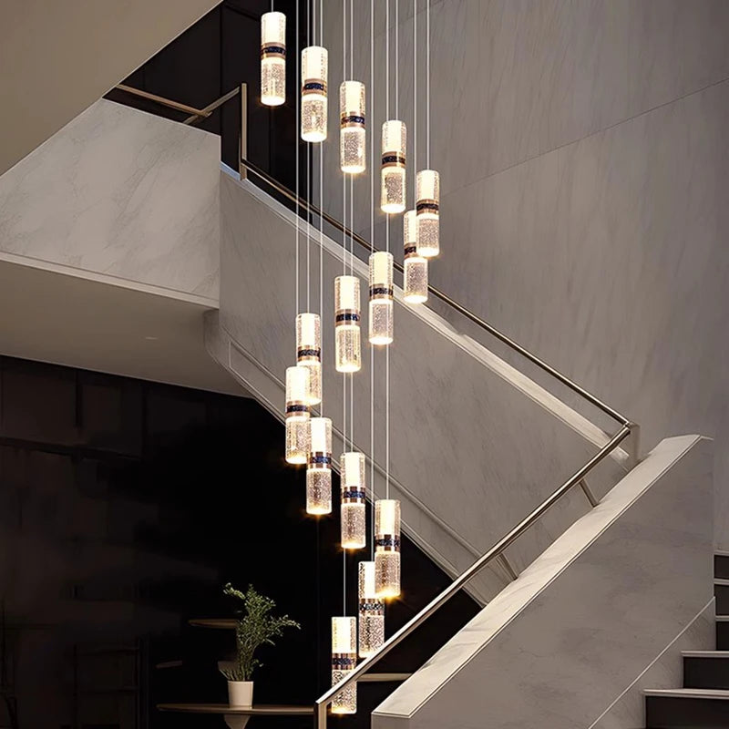 Modern crystal pendant lights illuminating a marble staircase with sleek metal railings.