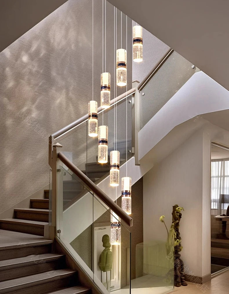 Modern crystal pendant lights hanging over staircase with glass railing, elegant interior lighting design
