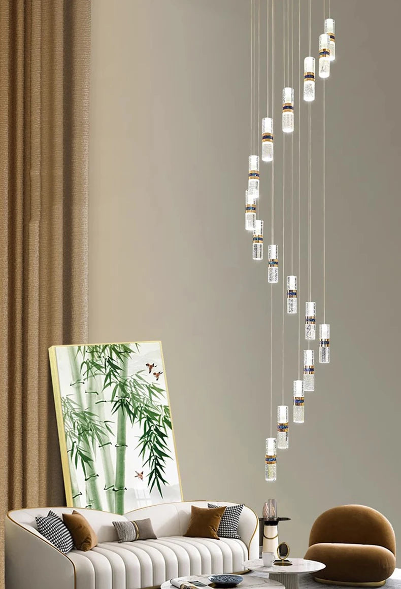 Modern crystal pendant lights with gold accents illuminate a stylish living room with sofa and bamboo art