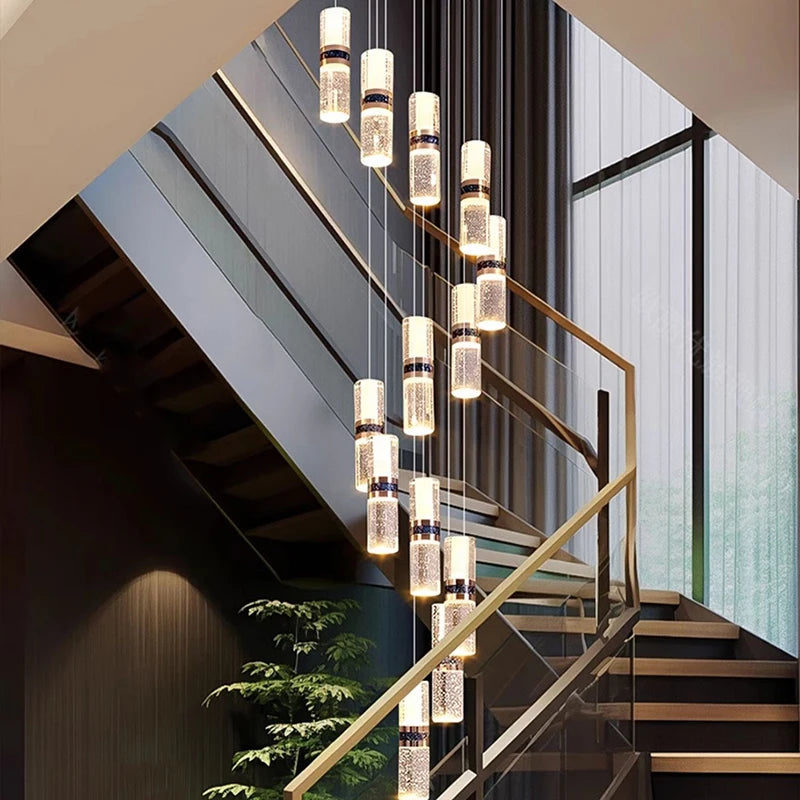 Modern crystal pendant lights illuminating a contemporary staircase with glass railings and warm ambient lighting.