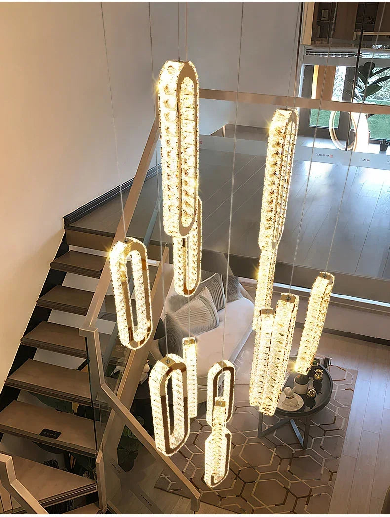 Modern crystal pendant lights illuminating a stylish staircase and living area with warm ambient glow
