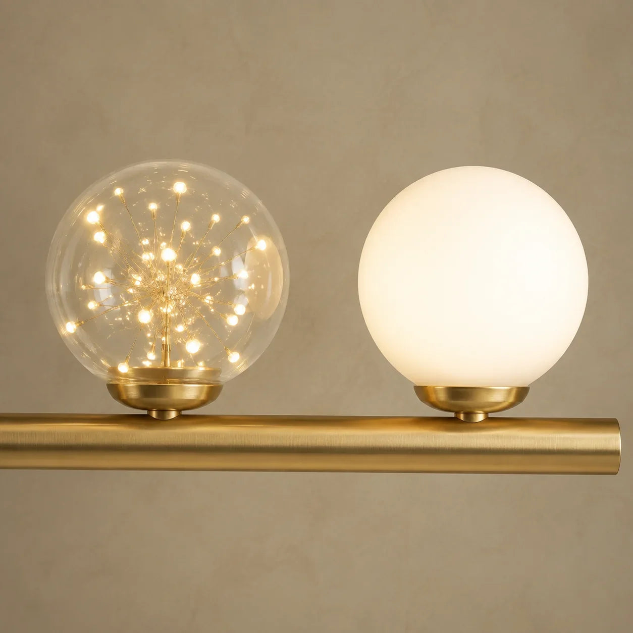 Detail view of Lyra Linear Chandelier's glass globes and gold-tone frame