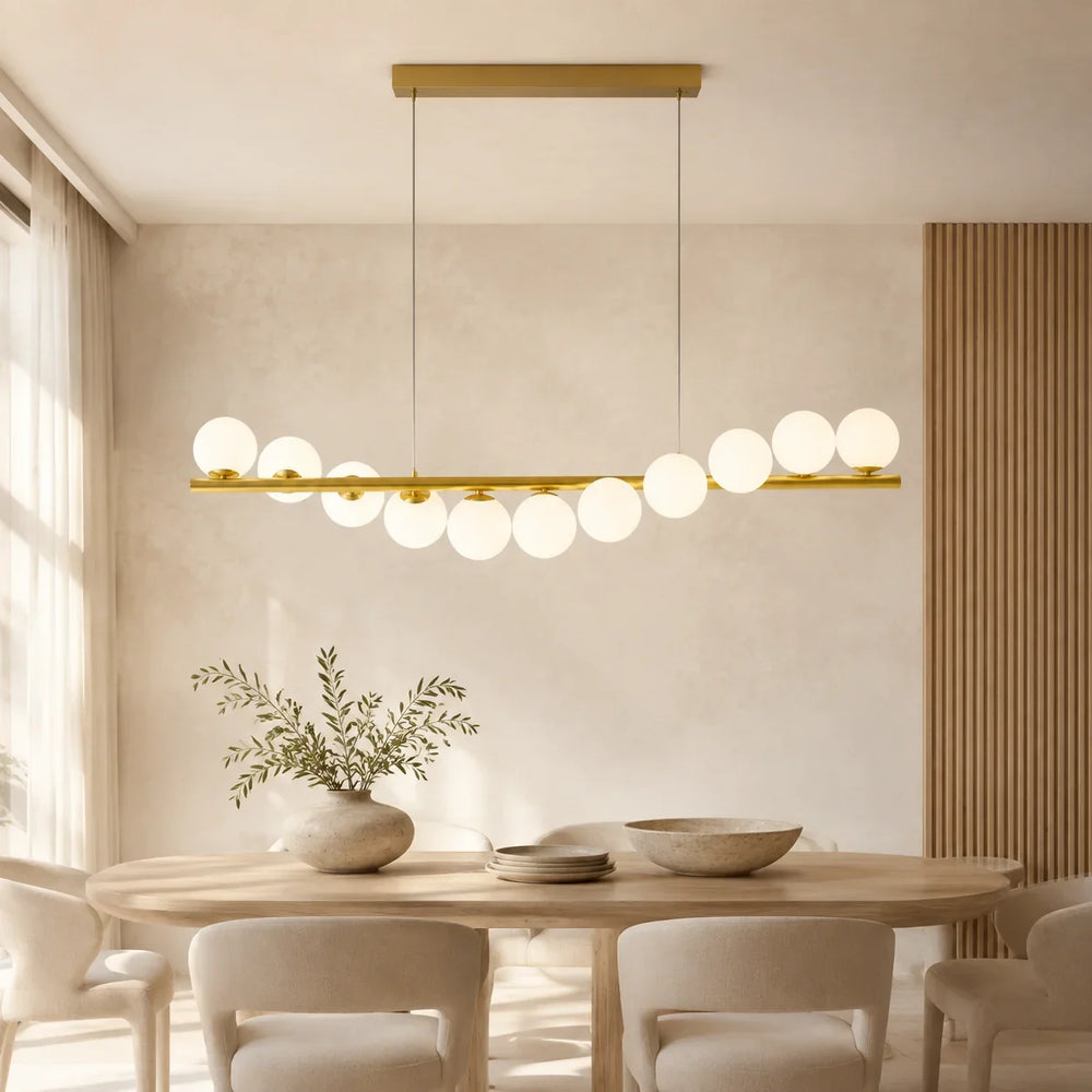 Lyra Linear Chandelier with illuminated glass globes along a slender gold-tone frame
