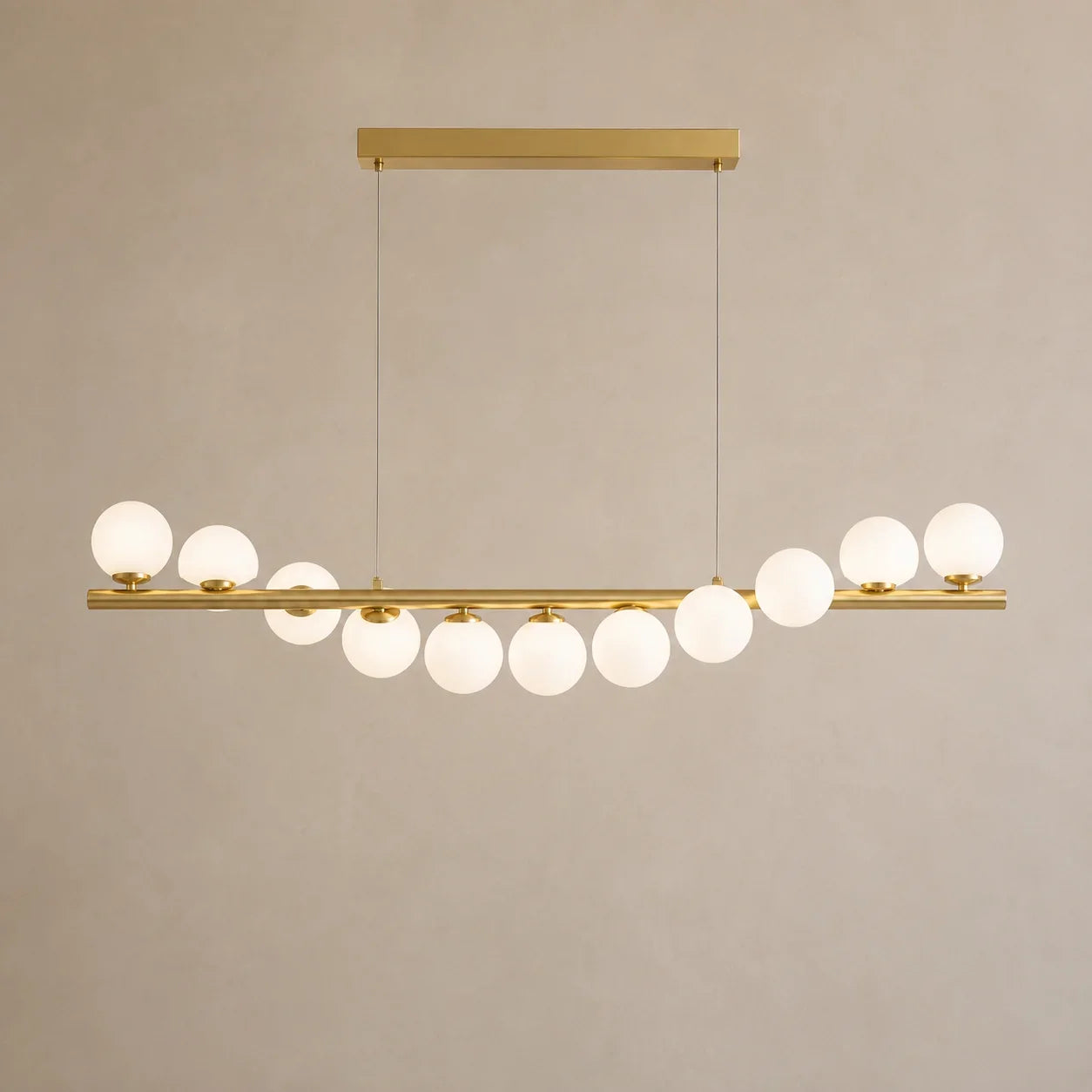 Lyra Linear Chandelier styled in a modern interior with illuminated glass globes
