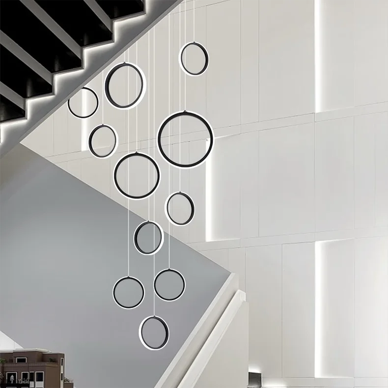Modern chandelier with black circular lights hanging from a white ceiling