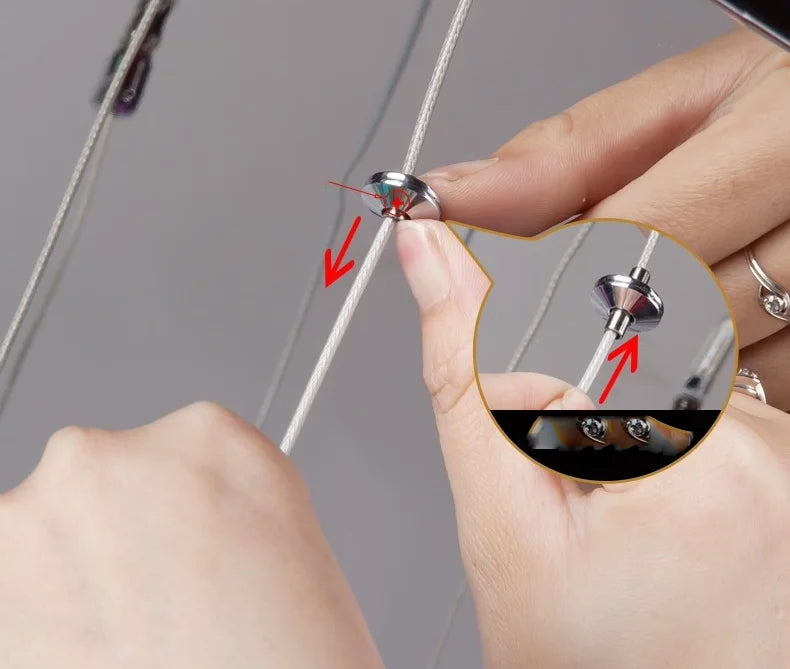 Close-up of a hand holding a small metal object with a gray background