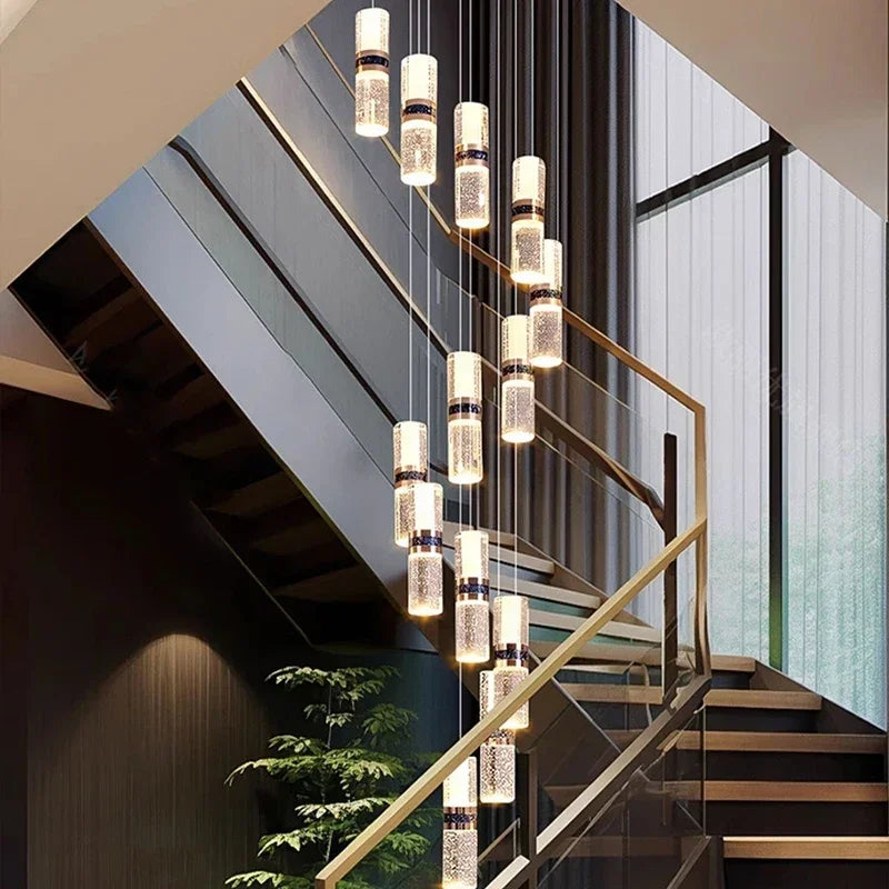 Modern crystal pendant lights illuminating a contemporary staircase with glass railings and warm ambient lighting.